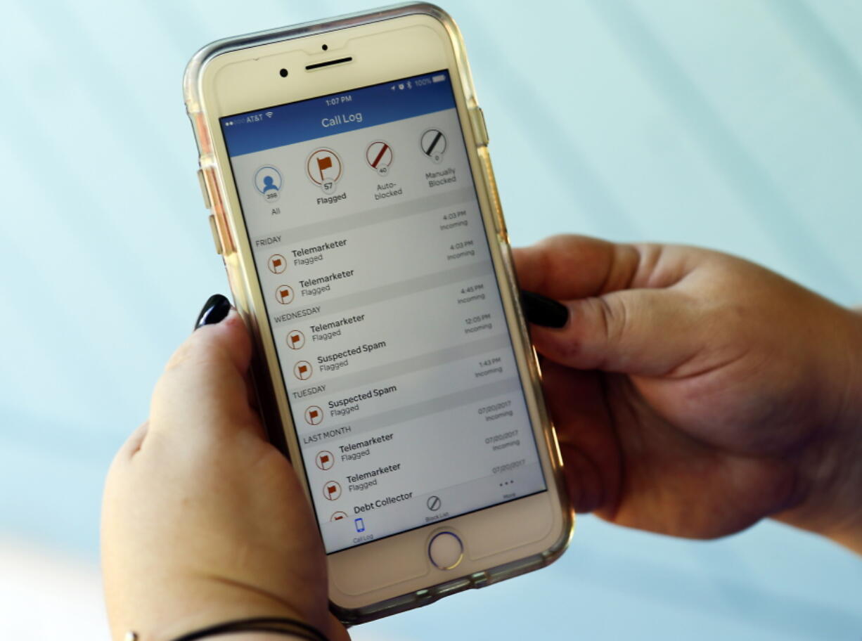 Jen Vargas looks at a call log displayed via an AT&T app on her cellphone at her home in Orlando, Fla. The app helps locate and block fraudulent calls although some robocalls still get through.