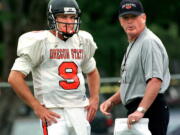 In this Wednesday, Aug. 18, 1999 file photo, Oregon State head football coach Dennis Erickson talks strategy with quarterback Jonathan Smith during practice in Corvallis, Ore. A person with direct knowledge of the decision says Oregon State has hired Washington co-offensive coordinator Jonathan Smith to be its new head coach. The person spoke to The Associated Press on Wednesday, Nov. 29, 2017 on condition of anonymity because an official announcement was being finalized.