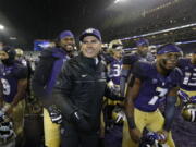 Washington head coach Chris Petersen, center, leads his team off the field after they beat Oregon 38-3 in an NCAA college football game, Saturday, Nov. 4, 2017, in Seattle. Washington won, 38-3. (AP Photo/Ted S.