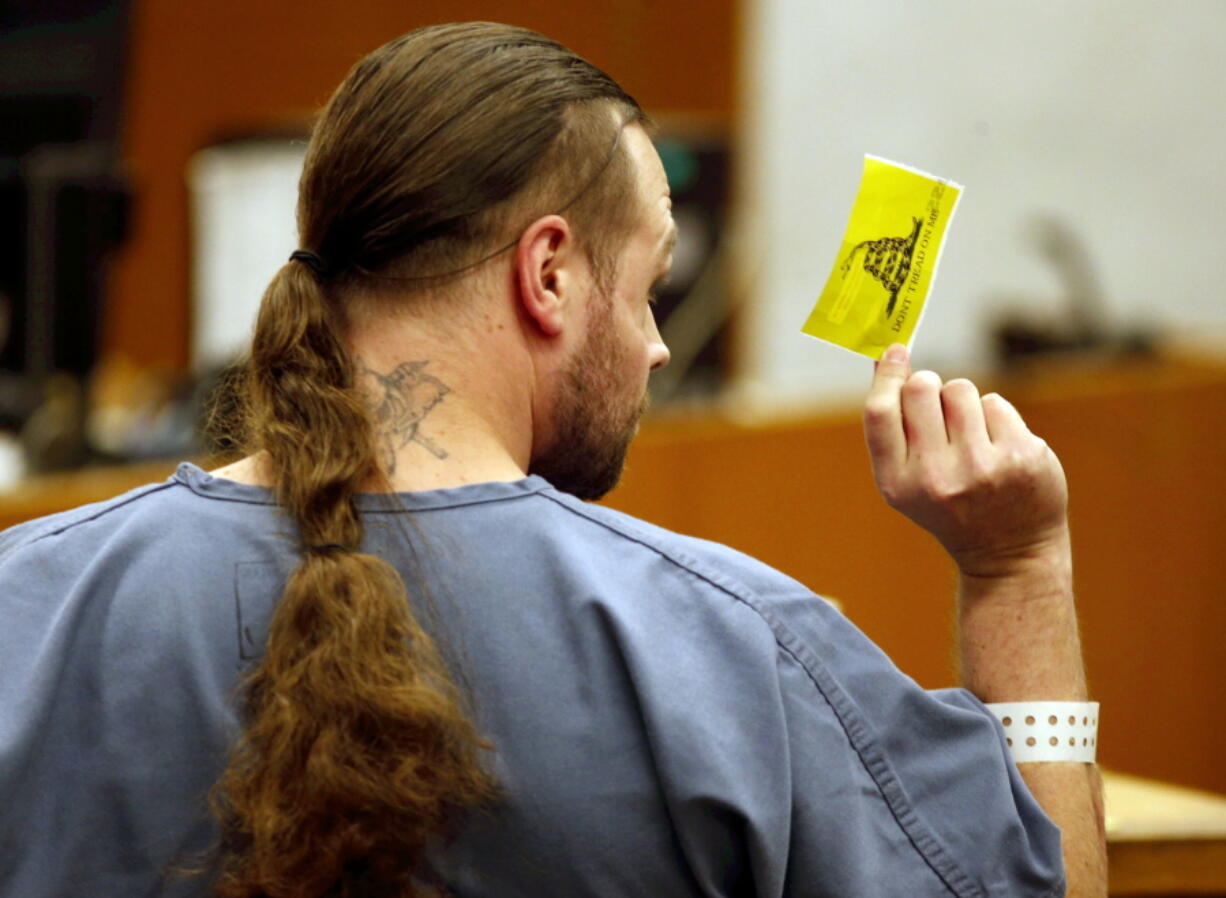 MAX stabbing suspect Jeremy Christian shows stabbing victim Micah Fletcher a “Don’t Tread on Me” sticker during a bail hearing on Wednesday in Portland.