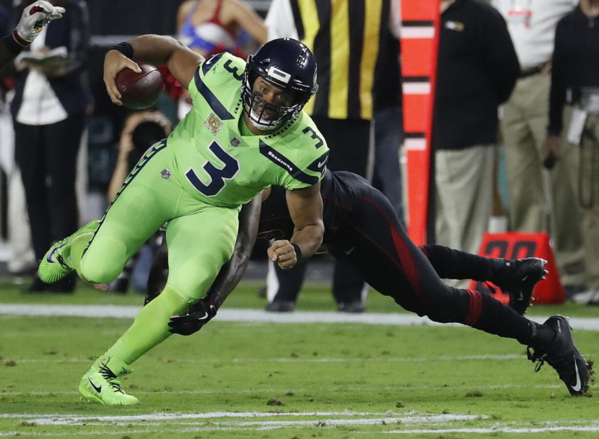 Seattle Seahawks quarterback Russell Wilson (3) eludes the tackle agasint the Arizona Cardinals during the first half of an NFL football game, Thursday, Nov. 9, 2017, in Glendale, Ariz.