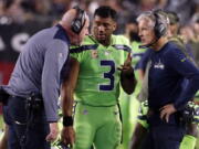 Seattle Seahawks quarterback Russell Wilson (3) speaks with head coach Pete Carroll, right, and assistant head coach Tom Cable during an NFL football game against the Arizona Cardinals in Glendale, Ariz.