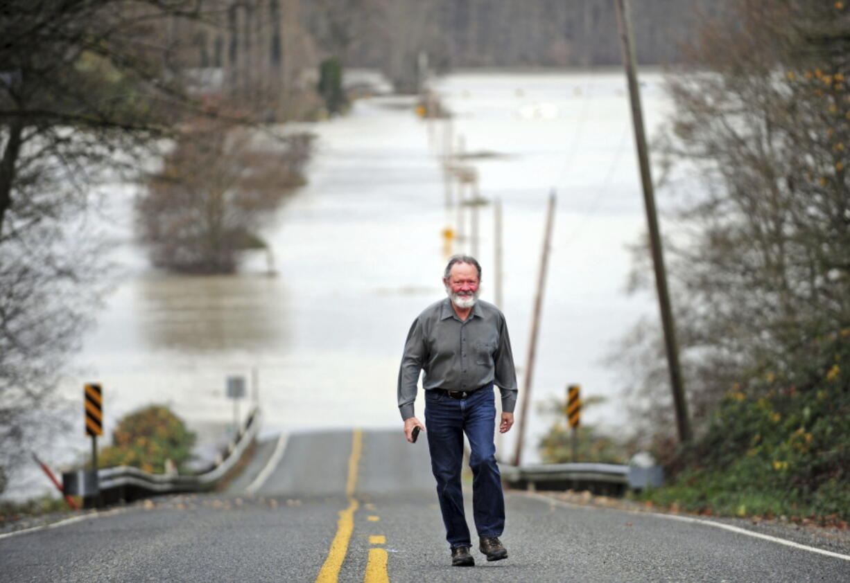 Chip Bergeron walks up the closed Francis Road in Mount Vernon after having a look at the floodwaters from the nearby Skagit River.