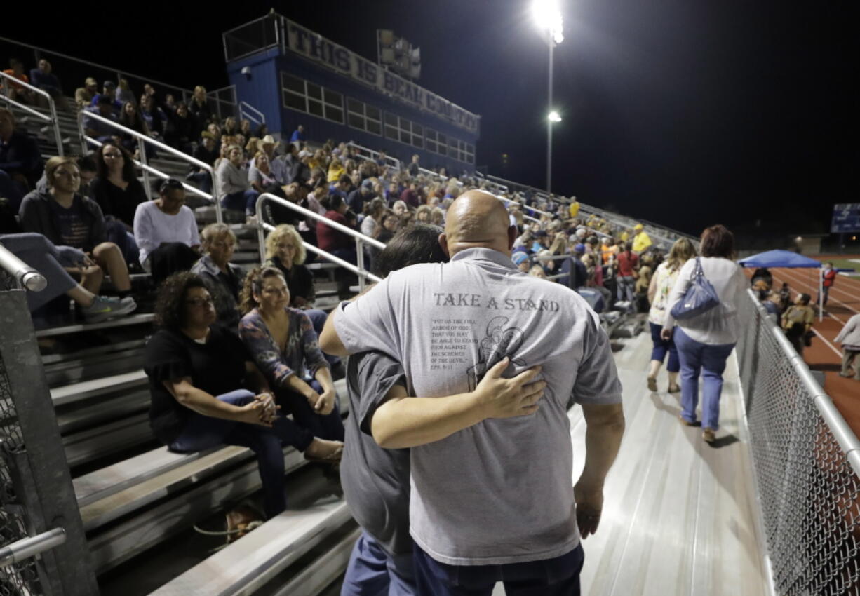 Attendees make their way through the stands of a football stadium before a vigil for the First Baptist Church shooting victims Tuesday in La Vernia, Texas. A man opened fire inside the church in the small South Texas community on Sunday, killing more than two dozen and injuring others. (AP Photo/David J.