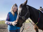 Abby Glenn, a student of Solid Ground Equine Assisted Therapy, pets the nose of Cash, a therapy horse, at the Griffith Ranch in Klamath Falls, Ore.