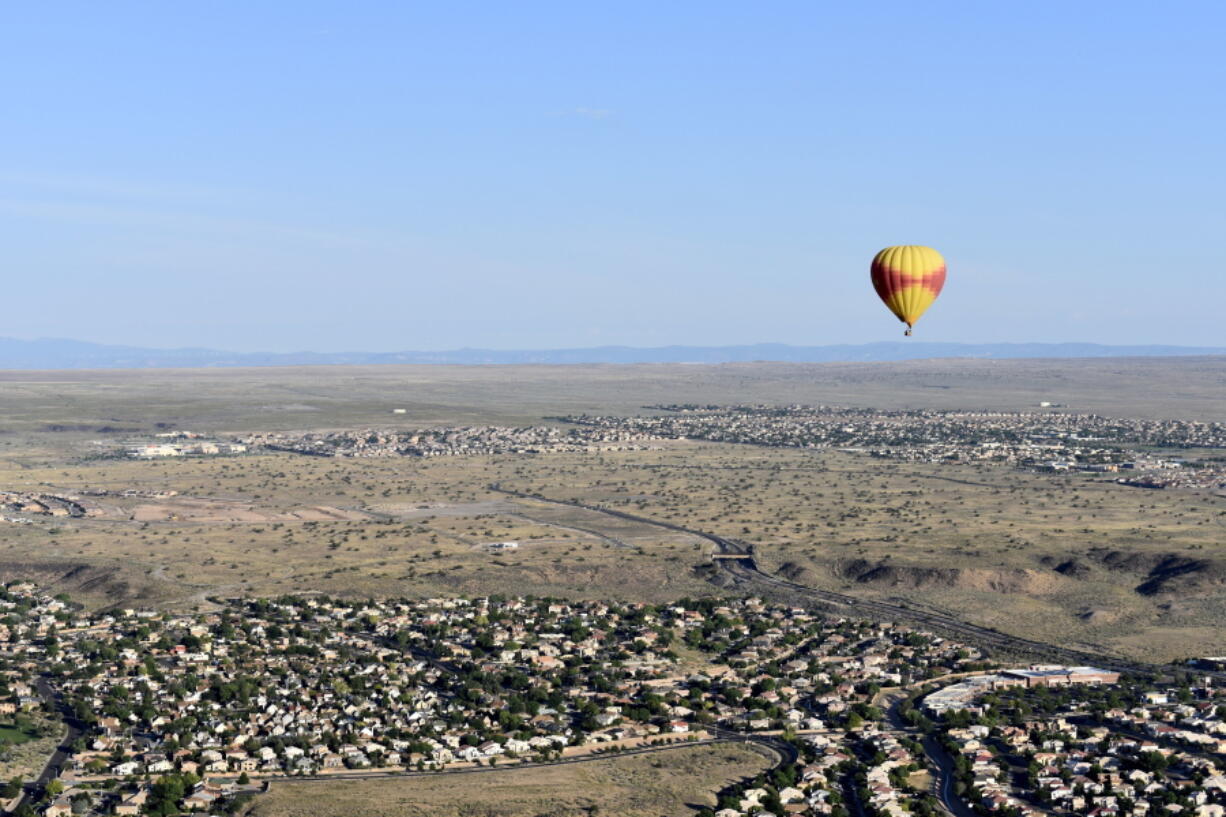 A Rainbow Ryders hot-air balloon hovers over the Rio Grande Valley surrounding Albuquerque, N.M., in July.