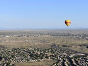 A Rainbow Ryders hot-air balloon hovers over the Rio Grande Valley surrounding Albuquerque, N.M., in July.