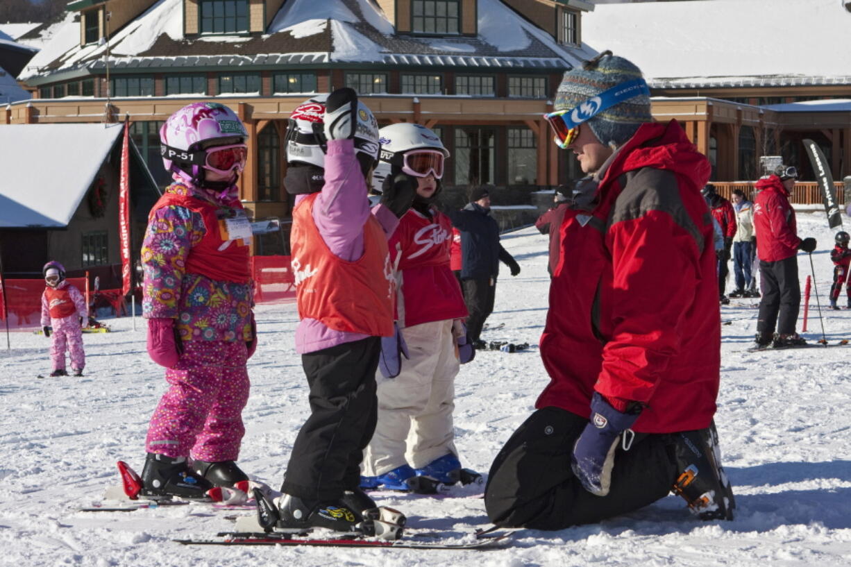 An instructor with young children in a ski lesson. Kids differ in their readiness and learning styles when it comes to learning to ski, but experts say the most important thing for parents to consider is making the experience fun.