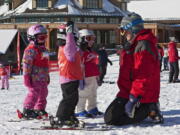 An instructor with young children in a ski lesson. Kids differ in their readiness and learning styles when it comes to learning to ski, but experts say the most important thing for parents to consider is making the experience fun.