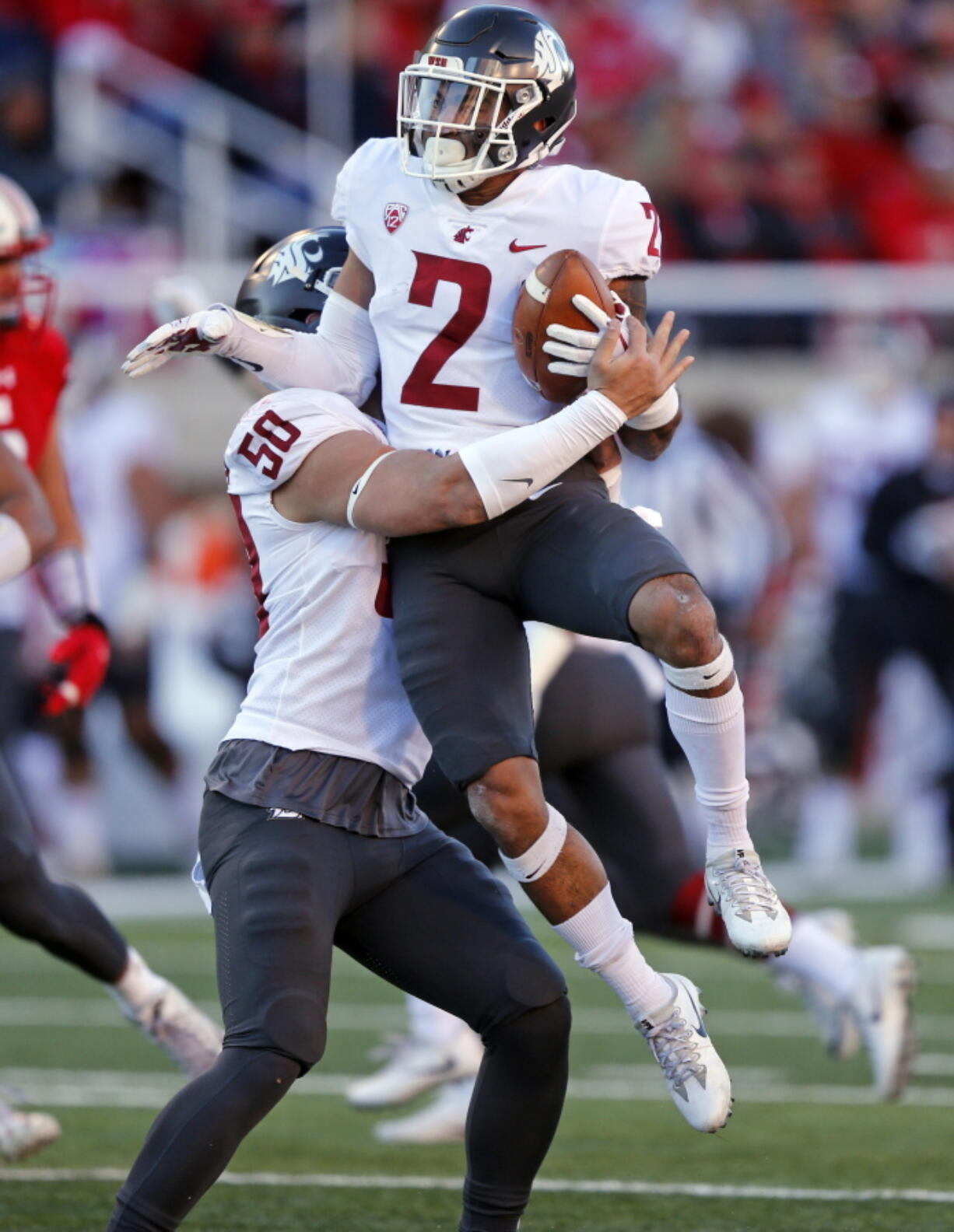 Washington State’s Hercules Mata’afa (50) lifts Robert Taylor (2) after his interception against Utah in the first half of an NCAA college football game, Saturday, Nov. 11, 2017, in Salt Lake City.