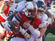 Washington State’s Hercules Mata’afa, right, and Frankie Luvu (51) sack Utah quarterback Tyler Huntley, foreground, in the first half of an NCAA college football game, Saturday, Nov. 11, 2017, in Salt Lake City.