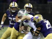 Oregon quarterback Braxton Burmeister is tackled by Washington linebackers Connor O’Brien, right, and Brandon Wellington, upper center. No. 9 Washington brings the best defense in the country into Friday’s matchup at Stanford. Ted S.