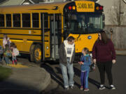 Jen Riley, from left, greets her daughter, Savannah, 8, with her wife, Kris, after school in Ridgefield on Tuesday afternoon.