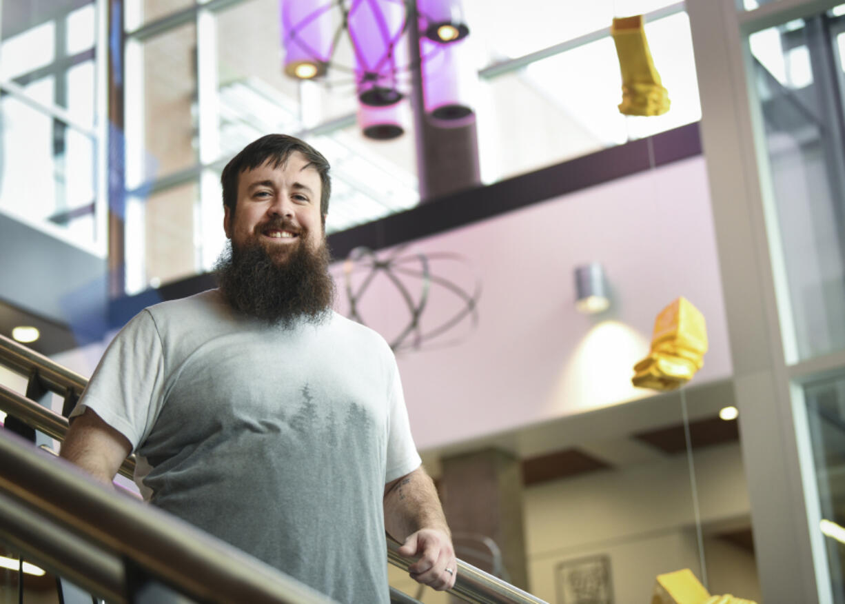 Cody Messick stands in the stairwell of the STEM Building at Clark College, with works of art that were that were crumpled or dented after being dropped from different heights to illustrate the force of gravity. He was part of a project that won the Nobel Prize in physics for discovering gravitational waves.