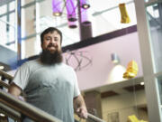 Cody Messick stands in the stairwell of the STEM Building at Clark College, with works of art that were that were crumpled or dented after being dropped from different heights to illustrate the force of gravity. He was part of a project that won the Nobel Prize in physics for discovering gravitational waves.