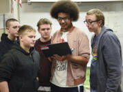 From left, Heritage High School students Seth Hastings, Landon Sanders, Daniel Adams, Terrence Lewis and Charles Chandler look at Lewis’ computer while designing a sound booth for their after-school game design team, the Heritage Lakoda Wolves.