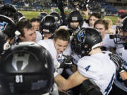 Hockinson surrounds quarterback Canon Racanelli as they celebrate their win against Tumwater after the 2A state football championship game Saturday, Dec. 2, 2017, in Tacoma, Wash.