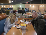 Tough times and estrangement behind them, Alora Munday-Davis and her father, Jon Munday, share laughs over dinner at Sushi Chiyo in Salmon Creek on a recent Tuesday night.