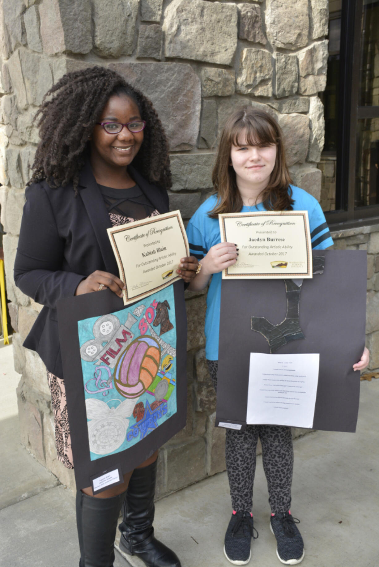 Washougal: Jemtegaard Middle School art students, from left, Kabiah Blain and Jaedyn Burrese were honored by district staff for their work, which has been hanging in the district office.