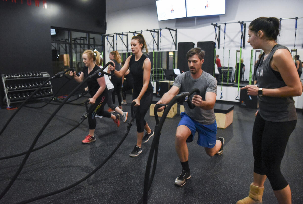 Jessica Denise, from left, Molly Maher and Jonathan Beckstead listen to directions from instructor Kathrine Kofoed at Burntown. The new high-intensity fitness studio opened in east Vancouver last month.