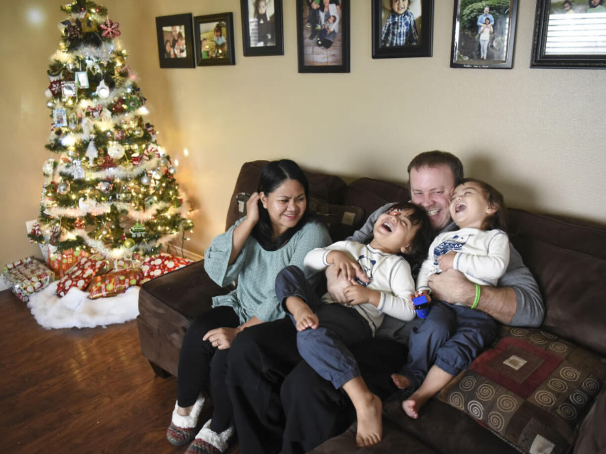 Melissa McAllister, left, watches as her husband, Guy McAllister, tickles their two sons, AJ, 3, and Christopher, 2, in their Vancouver home on Thursday. Melissa and her two sons were struck by a car while standing on a sidewalk in a nearby Safeway parking lot in July. This month, Melissa finally joined her family back home, after spending three months in the hospital and a skilled rehab facility.