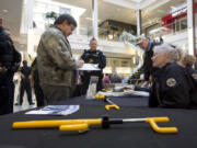 NOW volunteer Beth Christian, right, helps Karl Betersen get a free steering wheel lock Sunday in the Vancouver Mall. The Vancouver Police Department handed out the free locks as part of the department’s auto theft prevention program.