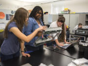 Vancouver iTech Preparatory freshman Emily Neumann, from left, junior Brooklyn Terry and freshman Elizabeth Zavala test out the wheels on their prototype during a robotics class at the school on Monday. The school boasts a curriculum preparing students for college and careers in science and engineering fields. But with a predominantly white student body, experts worry iTech and similar magnet schools are exacerbating barriers for students of color.