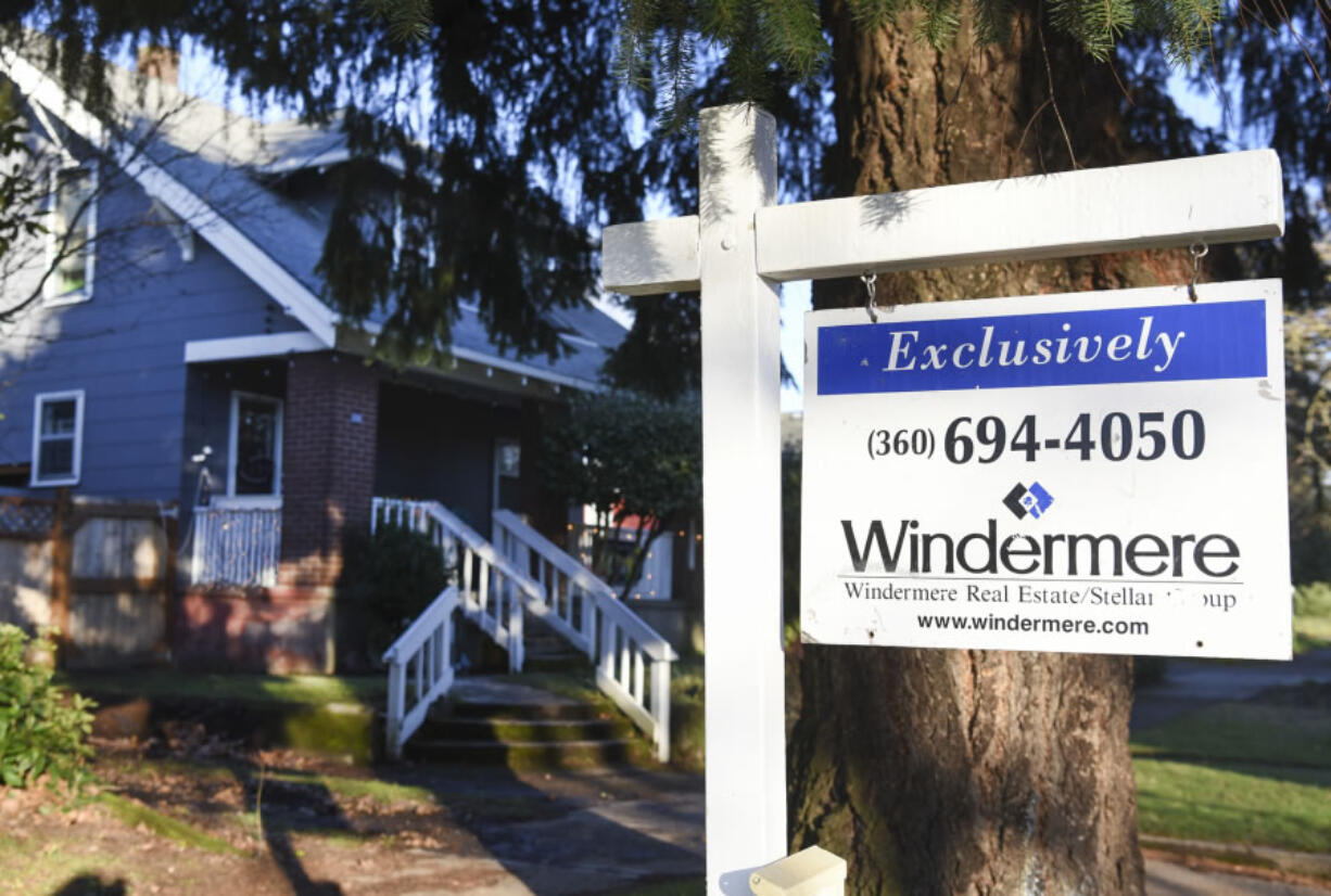 Wattle Tree Place is pictured behind a for-sale sign on East 16th Street. Recently, the entire street block containing six homes was sold.