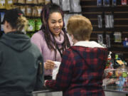 Kayzla Worlitz, assistant manager at Sticky’s Pot Shop in Hazel Dell, hands a customer a bag of the store’s merchandise on Wednesday. The shop remains open, despite a county ban, while the law is contested in the courts.