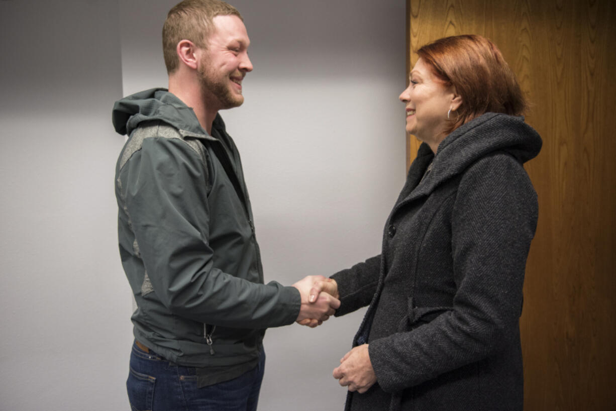 Clark Public Utilities employee Josh Vincent and Laurel Faught, both of Vancouver, meet in person for the first time at a Clark Public Utilities office in Vancouver on Friday. During a customer service call with Faught last March, Vincent noticed something sounded abnormal and called 911. Doctors later told Faught and her family that Vincent’s call likely saved her life.