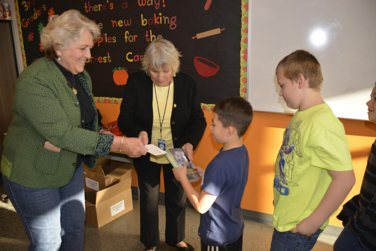 Washougal: Camas-Washougal Rotary Club members Molly Coston, from left, and Joyce Lindsay present dictionaries to Columbia River Gorge Elementary School third-graders Noah Migaki, Trenton Rogers and Joshua Homuth.