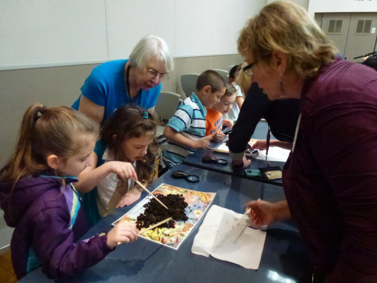 Hazel Dell: Washington State University Master Gardeners Genda McCune, left, and Linda Ricciardi look on as first-grade students from Hazel Dell Elementary School explore compost and find red wiggler worms and other soil life.