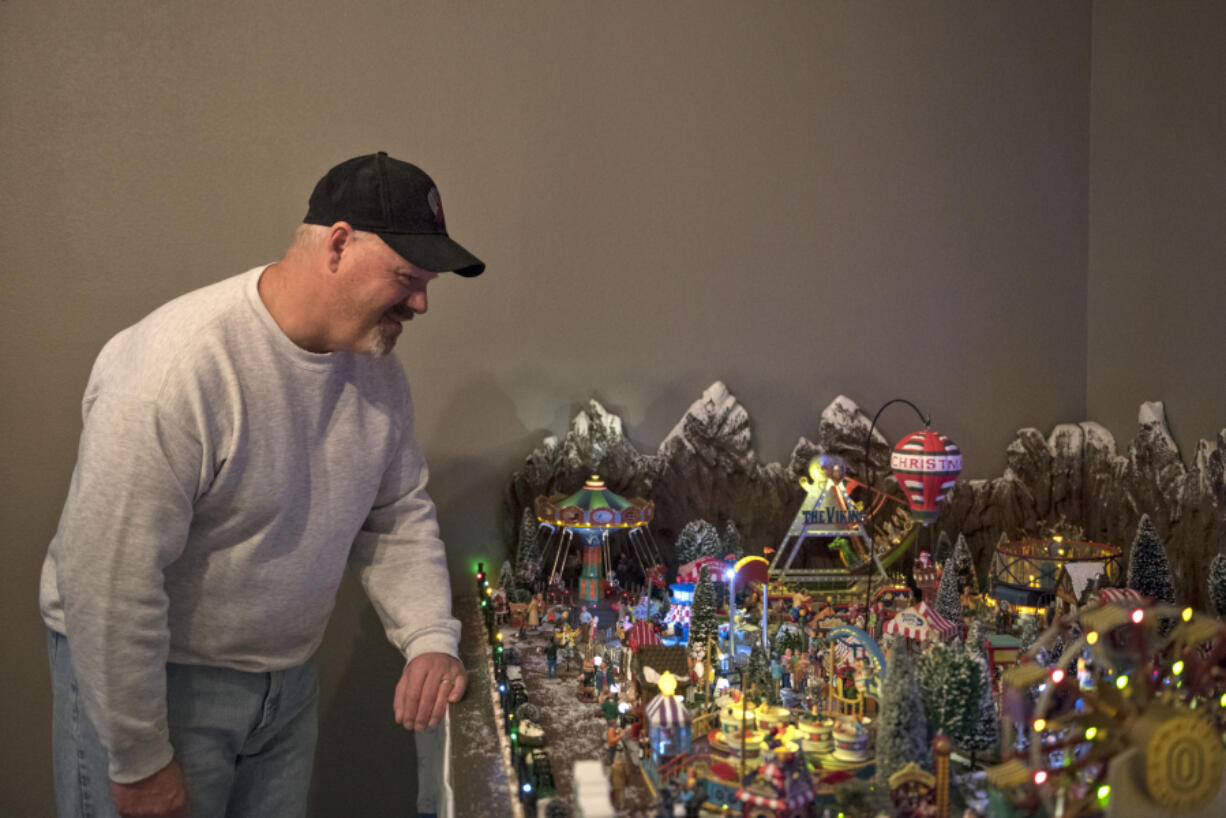 Dan Savage looks over his hand-built Christmas carnival displayed in his Vancouver home. The carnival includes numerous buildings and more than 300 figures, as well as multiple handcrafted pieces. Overall, the display is 4½ feet wide and 11 feet long.