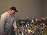 Dan Savage looks over his hand-built Christmas carnival displayed in his Vancouver home. The carnival includes numerous buildings and more than 300 figures, as well as multiple handcrafted pieces. Overall, the display is 4½ feet wide and 11 feet long.