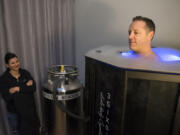 Liza Anzellotti monitors the cryotherapy sauna as her husband, Dave Anzellotti, demonstrates how it is used Tuesday at 3SIX0 Fitness in Vancouver. Whole-body cryotherapy is said to reduce inflammation and chronic pain, and accelerate athletic recovery.