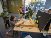 Reid Swank, 9, of Vancouver works with his sister Tayden, 10, as they film a stop-motion movie Wednesday afternoon at Vancouver Community Library. Students used an application on tablets for the project, which allowed them to take photos and stitch them together.