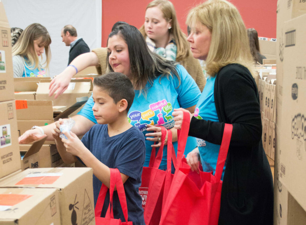 Orchards: Platinum Pets employees volunteered packing bags with daily items for guests attending Share’s holiday party.