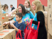 Orchards: Platinum Pets employees volunteered packing bags with daily items for guests attending Share’s holiday party.