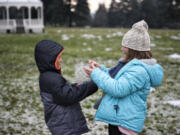 Lucca Pasquini, 7, left, and Layla Pasquini, 10, both of Santa Cruz, Calif., played with ice near the bandstand at Fort Vancouver on Tuesday. The siblings, who spent Christmas playing with ice and sledding down the street while visiting family in Vancouver, could see more wintry weather Wednesday morning, when the forecast calls for freezing rain.