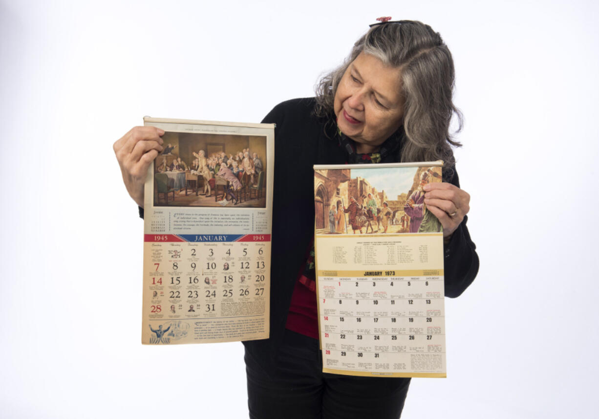 Cyrilla Gleason of Vancouver holds two of her vintage calendars — 1945, left, and 1973 — on Thursday. Both are usable in 2018.