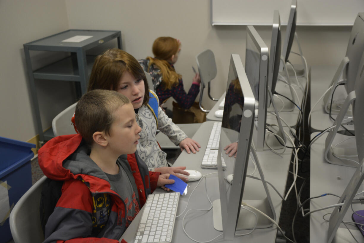 Washougal: Hathaway Elementary School first-grader Jason Burden, left, and fourth-grader Virginia Burden participate in the school’s Hour of Code event during Computer Science Education Week.