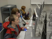 Washougal: Hathaway Elementary School first-grader Jason Burden, left, and fourth-grader Virginia Burden participate in the school’s Hour of Code event during Computer Science Education Week.