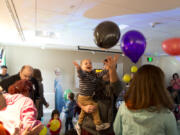 Reed Rissler, 2, swats at celebratory balloons with his father, Ryan Rissler of Camas, during the Camas Public Library’s Noon Year’s Eve dance party Saturday.