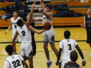 Prairie guard Kam Osborn goes up with a contested layup against two Skyview defenders. The Storm defeated Prairie 57-52 at Skyview High School on Tuesday night to improve to 2-0 on the season.