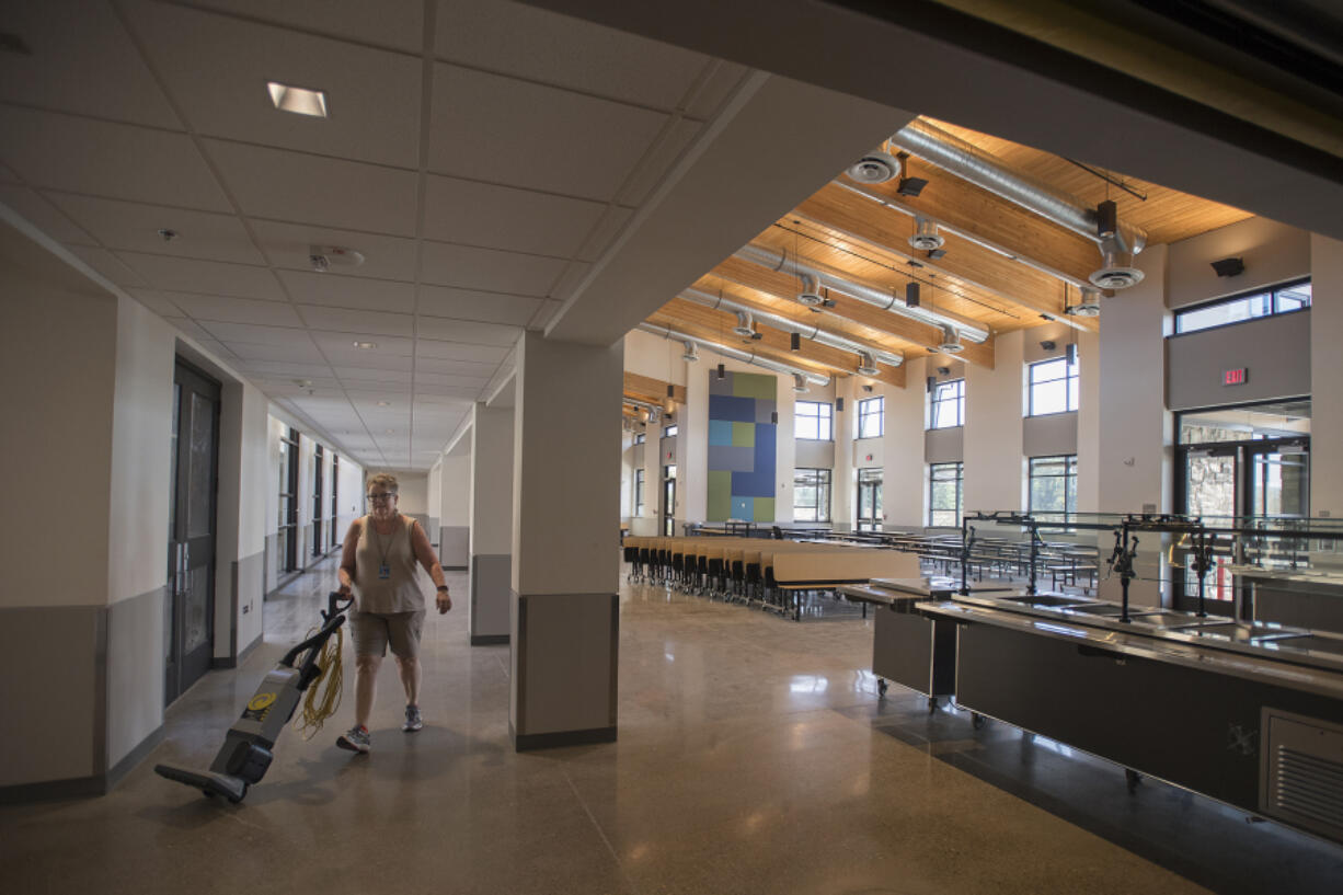 Custodian Trish Happs makes her way through the cafeteria shared by Columbia River Gorge Elementary School and Jemtegaard Middle School in late August while preparing for the start of school.