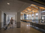 Custodian Trish Happs makes her way through the cafeteria shared by Columbia River Gorge Elementary School and Jemtegaard Middle School in late August while preparing for the start of school.