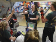 Evergreen junior Kerissa Andersen, center, reaches out to high-five bowling teammates Dakota OíNeil, left, and Alexis Henderson, right, after making a strike during the season opening jamboree at Crosley Lanes in Vancouver, Thursday November 9, 2017.