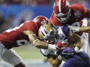 Washington running back Myles Gaskin (9) is tackled by Alabama defenders in last yera’s Peach Bowl. This year, Gaskin and other Husky returners are no longer in awe of playing in a big-time bowl game.