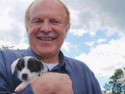 Democratic state Sen. Raymond Lesniak holds a rescue puppy at a “Paws Walk for a Cause” fundraiser in New Jersey.