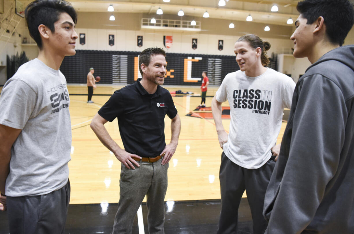 Brad Butterworth, a 39-year-old from Camas, talks with teammates on the Portland Bible College basketball team, Keoni Peneueta, left, Willie Bratcher, and Kenese Peneueta.